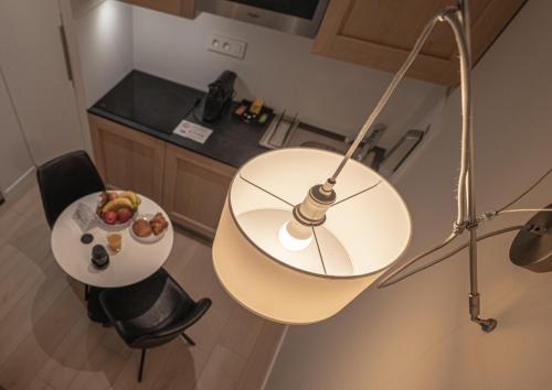 a table with a lamp and a plate of food on it at Five Resort Cholet Centre in Cholet