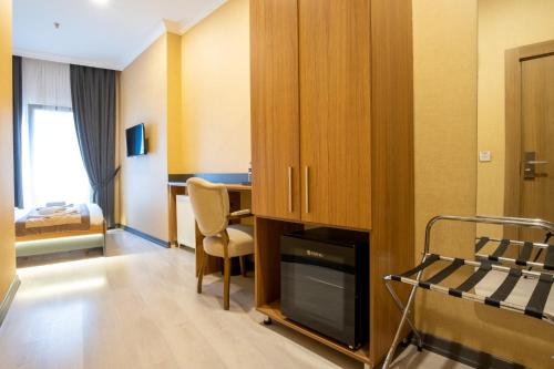 a hotel room with a desk and a bedroom at Orange Hotel & Spa in Şişli