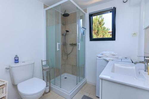 a bathroom with a shower and a toilet and a sink at Loc Ty Home in Soustons