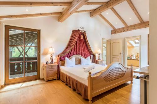 a bedroom with a large bed with a red canopy at Ferienhaus mit Bergpanorama in Unterwössen