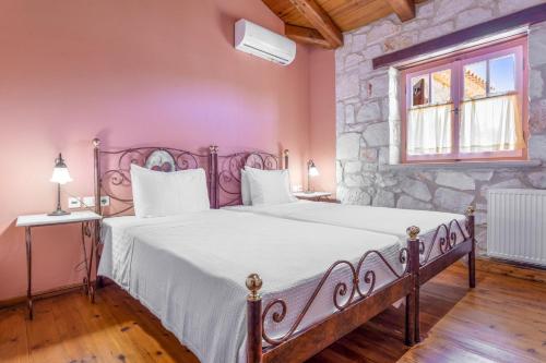a bedroom with a large bed with a stone wall at Villa Ira in Agios Leon