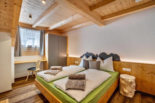 a bedroom with a large bed in a room with wooden ceilings at Krämerhof Apt Aferer Geisler in Rodengo