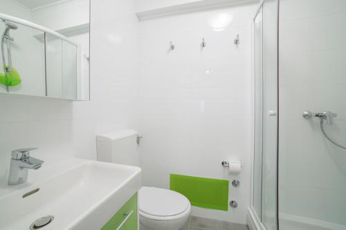 een witte badkamer met een toilet en een douche bij Gornji grad Apartman in Zagreb