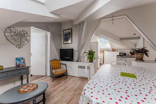 a room with a bed and a table and a kitchen at Appartement de maitre traversant in La Teste-de-Buch