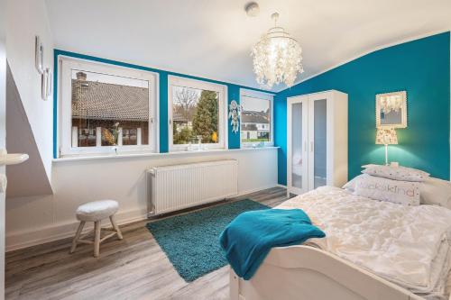 a blue and white bedroom with a bed and windows at Ferienwohnung Solling-Lounge in Holzminden