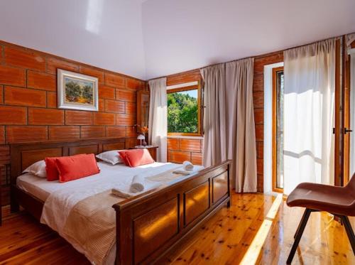 a bedroom with a large bed with red pillows at Stone oasis Marin in Žrnovo