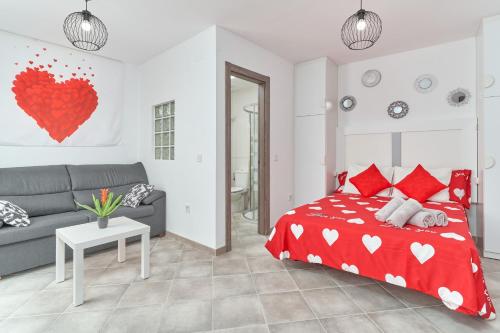 a bedroom with a red bed and a couch at Nerja Boutique 103 Sweet Corner in Nerja