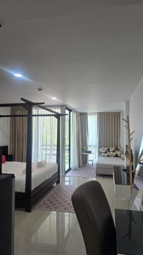 a bedroom with two beds and a living room with a table at joyful the Kris406 in Ban Lum Fuang
