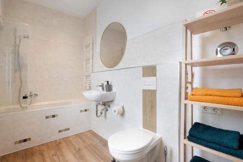 a bathroom with a toilet and a sink and a mirror at Ferienwohnung Finsterwalde 2 in Finsterwalde
