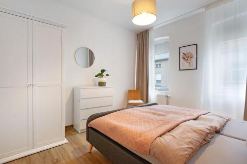 a white bedroom with a bed and a dresser at Ferienwohnung Finsterwalde 2 in Finsterwalde