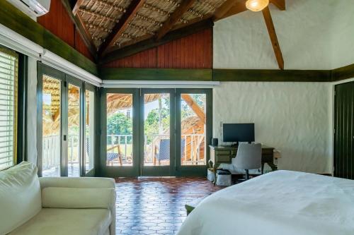 a bedroom with a bed and a desk with a computer at Ocean View Villa, Pool, BBQ, Jacuzzi, Staff Incl in Cajuiles