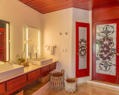 a bathroom with a sink and a red door at Ocean View Villa, Pool, BBQ, Jacuzzi, Staff Incl in Cajuiles