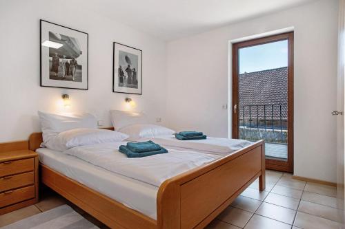 a bedroom with a large bed with a window at Gästehaus Heinemann - Og5 in Langenargen