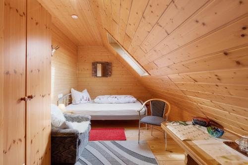 a small room with a bed in a wooden cabin at Gästehaus Waldhüsle in Friedenweiler