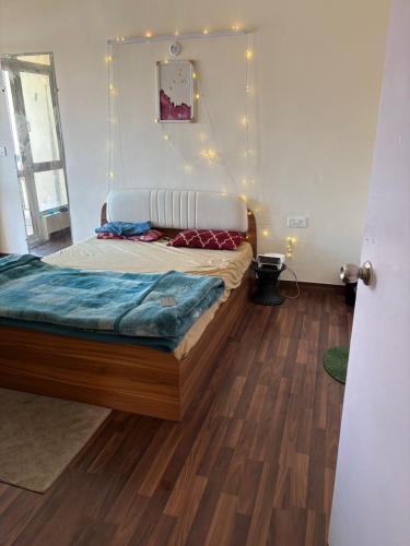 a bedroom with a bed and a wooden floor at Express view homes in Noida