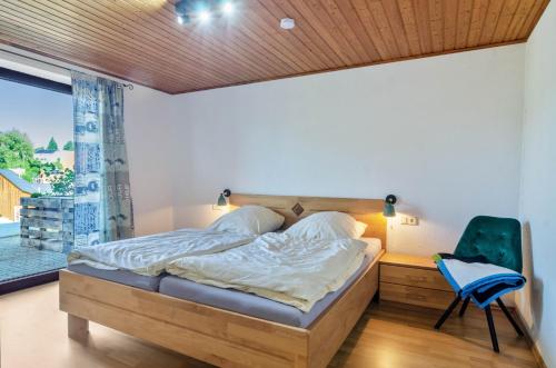 a bedroom with a bed and a chair and a window at Fribo in Ostrach