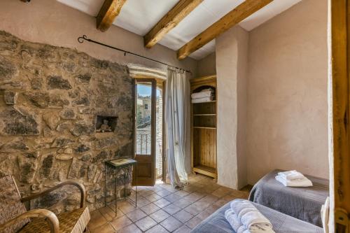a room with two beds and a stone wall at Casa de Pueblo in Cantallops