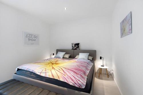 a bedroom with a bed with a colorful blanket on it at Ferienwohnung 20b am Goitzsche See in Pouch