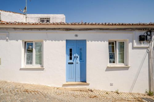 a white house with a blue door at Casa Do Castelo in Beja