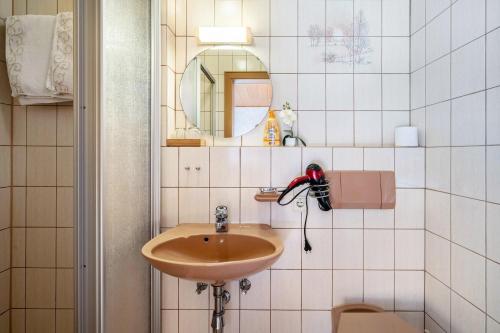 a bathroom with a sink and a mirror and a toilet at Gästehaus Absbachtal in Bad Rippoldsau-Schapbach