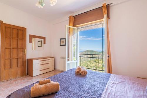 a bedroom with a bed and a large window at Sa omu de sa palgia in Jerzu