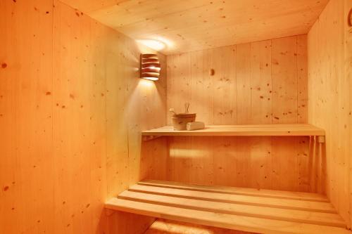 a sauna with a wooden wall with a light on it at Tra-monti e Mare Bormio in Valdidentro