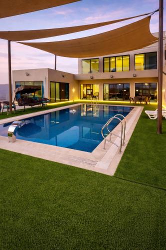 a house with a swimming pool in front of a house at Devon Chalet in Amman