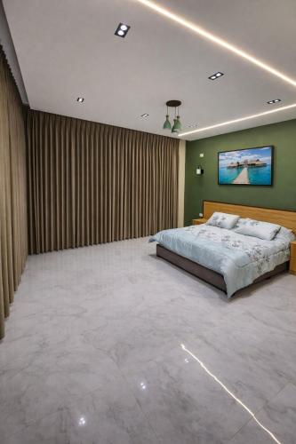 a bedroom with a large bed and a painting on the wall at Devon Chalet in Amman