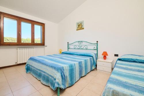 a bedroom with two beds and a window at Mare Etrusco Villetta D2 in Populonia