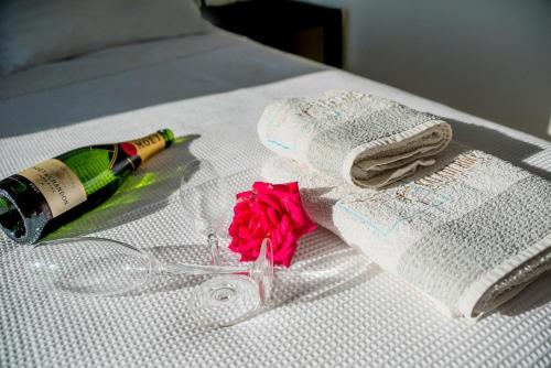 a bottle of champagne and a rose on a bed at Kaladi Rock Avlemonas in Avlemonas