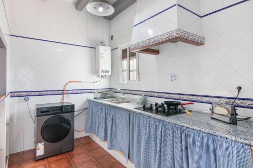 a small kitchen with a stove and a microwave at Finca El Abuelo in Lepe