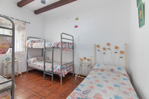 a room with two bunk beds and a tiled floor at Finca El Abuelo in Lepe