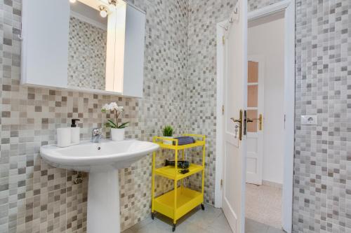 a bathroom with a sink and a yellow shelf at Villa Brisa de Gairia in Antigua