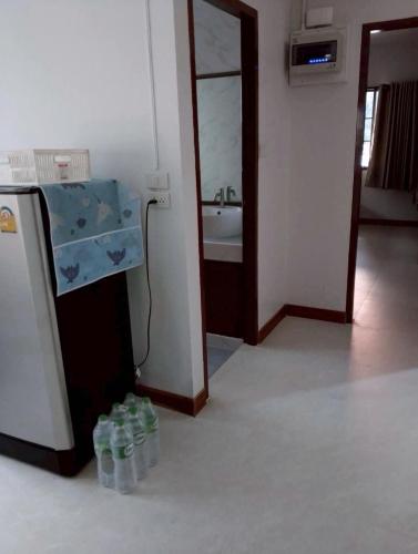 a room with bottles of water sitting next to a refrigerator at บ้านกรรณิการ์ in Chiang Mai