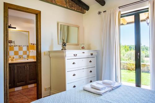 ein Schlafzimmer mit einem Bett, einer Kommode und einem Spiegel in der Unterkunft Amaltea in Candeleda
