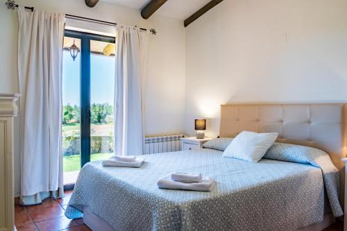 ein Schlafzimmer mit einem Bett und einem großen Fenster in der Unterkunft Amaltea in Candeleda