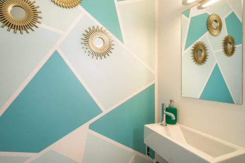 a bathroom with a blue and white geometric wall at Kilian in Schwarzach