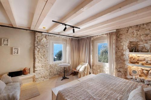 a bedroom with a bed and a stone wall at Cozy Sommavilla Residence in Brenzone sul Garda