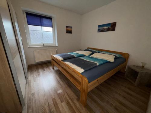 a bedroom with a bed in a room with a window at Ferienwohnung Charly in Carolinensiel