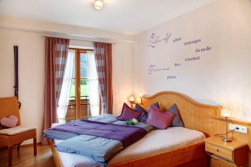 a bedroom with a bed with purple pillows at Landhaus Bergkulisse in Wallgau