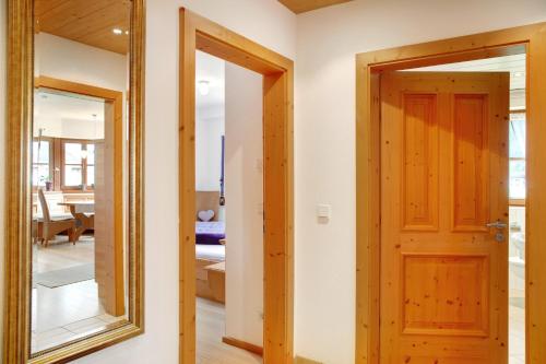 a hallway with a mirror and a door at Landhaus Bergkulisse in Wallgau