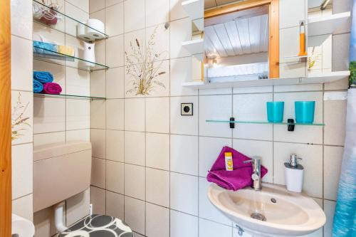 a small bathroom with a sink and shelves at Haus Strohmeier in Brandenberg