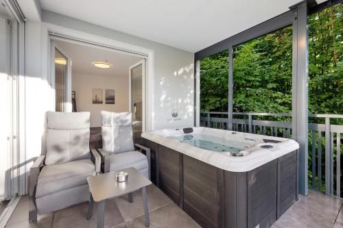 a bathroom with a tub and a chair and a window at Egge Resort 7a mit Whirpool u Sauna in Altenbeken