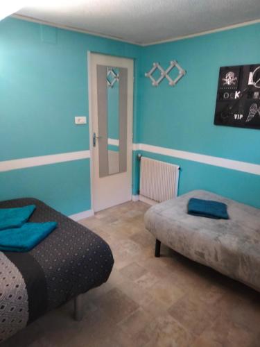 Un dormitorio con paredes azules y una cama y una puerta. en Chez Léa, en Bourges