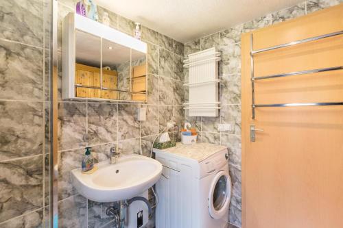 a bathroom with a sink and a washing machine at Ferienhäuschen Wils in Borkheide