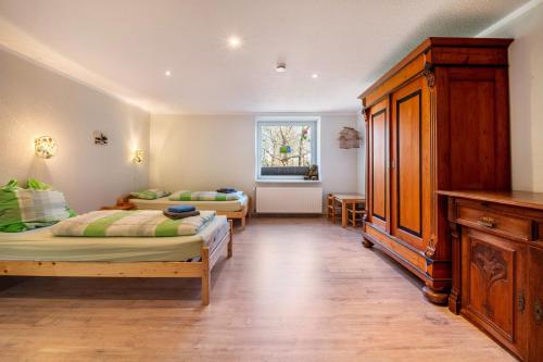 a bedroom with two beds and a dresser at Ferienwohnung Ankerplatz in Osterbruch