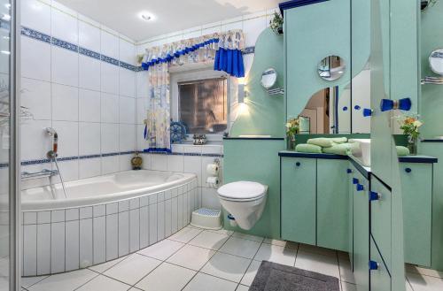 a bathroom with a tub and a toilet and a sink at Ferienhaus In Oerrel Mit Pool in Munster
