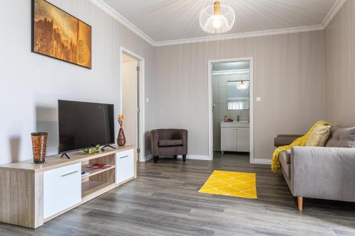 a living room with a couch and a television at Oásis Fonte Grande in Ponta Delgada