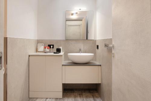 a bathroom with a white sink and a mirror at Appartamento Alice in Caiolo