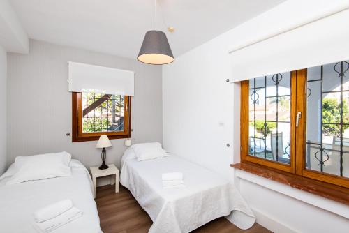 two beds in a white room with windows at Best place Playamar in Torremolinos